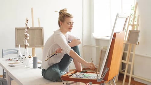 Young Artist Painting in Sunny Studio