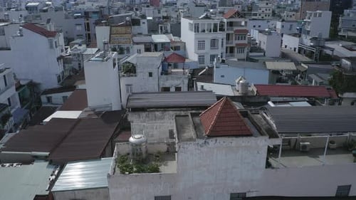 drone shot flying low over rooftops in urban residential area of major city in South East Asia. Show