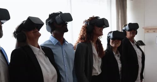 Multiracial teamwork having fun wearing virtual reality headset inside coworking office