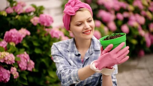 Happy Woman Gardener Care Flowers in Garden