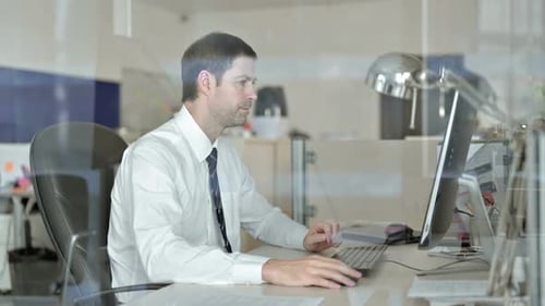 Middle Aged Businessman Working on Office Computer
