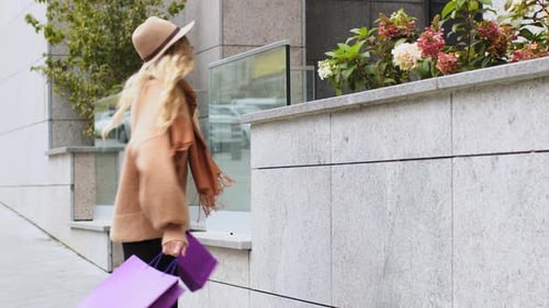 Jeune belle fille dansant joyeusement dans la rue de la ville Une femme caucasienne accro au shopping se réjouit des réductions