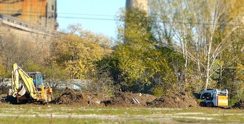 Construction Vehicles Working on Dirt Piles