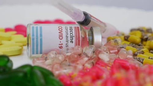 Covid-19 Vaccine Vial and Pills Close Up