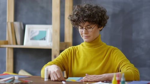 Woman Creating Colorful Paper Art Collage at Desk