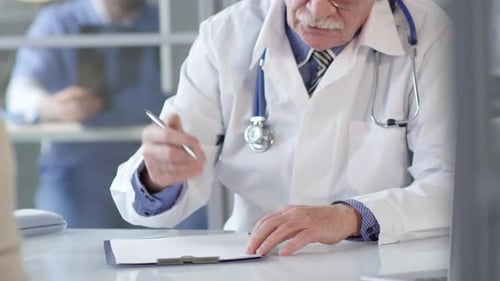 Senior Doctor Consults with Patient in Clinic