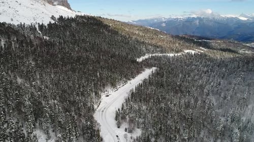 Winter Forest White Snow Mountains and a Road Aerial View