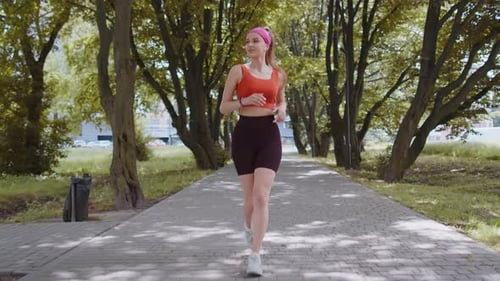 Athletic Fitness Sport Runner Girl Training Marathon Run Listening Music in Earphones Morning Park