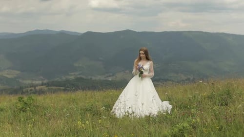 Beautiful Bride with Bouquet in Mountain Meadow