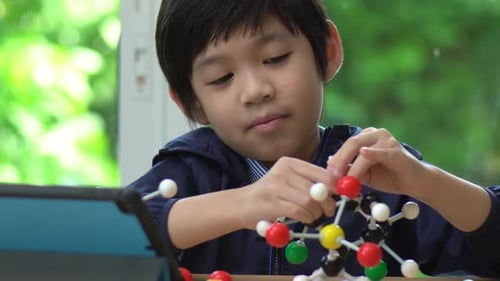 Boy Builds Molecular Model at Table Indoors