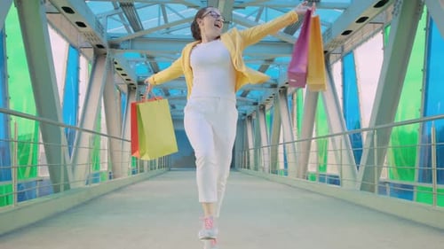 Femme heureuse avec des sacs de courses sortant du magasin
