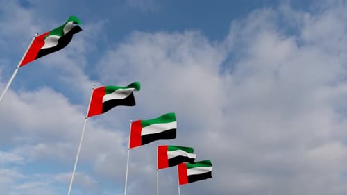 United Arab Emirates Flags Waving in Wind Against Blue Sky