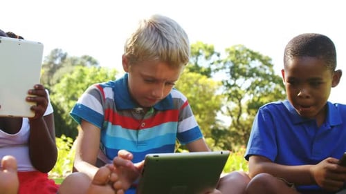 Group of kids using mobile phone and digital tablet