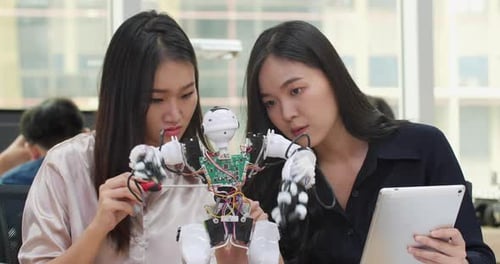 Young Women Working on a Robot Project