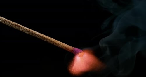 Match Ignites and Burns in Dark Close Up