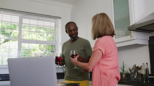 Couple Toasting with Red Wine in Kitchen