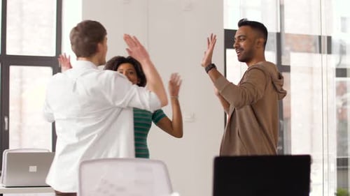 Happy Creative Team Making High Five at Office 49