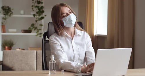 Portrait of Business Woman Sitting at Table at Home in Room or Office in Company, Wears Protective