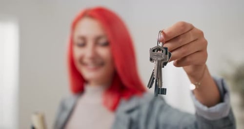 Shot of Apartment Keys Extended on Hand Toward Camera Pinkhaired Woman Dressed in Suit Holds