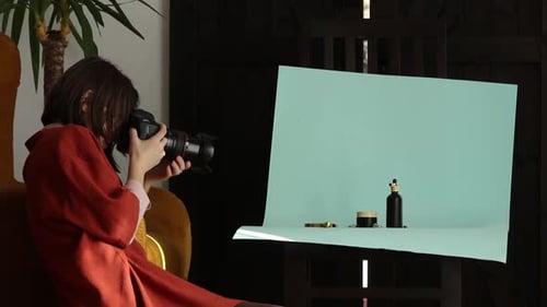 Woman Photographing Beauty Products with Camera Indoors