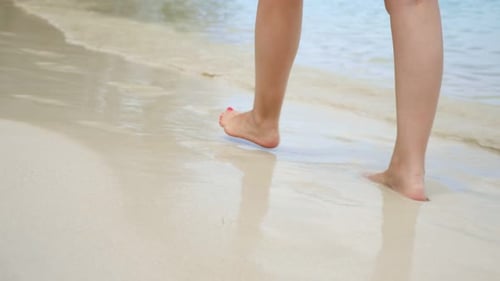Woman Walks Along the Beach