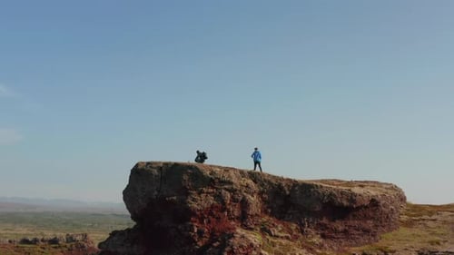 Landing Drone View of Two Climbers Backpackers Feeling Free Top of Hill in Iceland