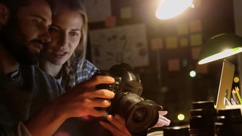 Man and Woman Reviewing Photos on Camera