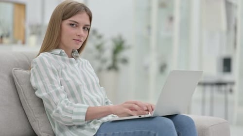 Woman Working on Laptop Gives Thumbs Up Indoors
