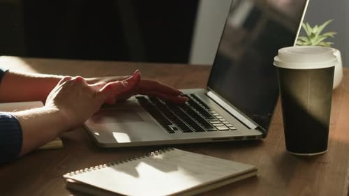 Typing on Laptop at Wooden Desk With Coffee