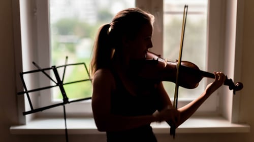 Woman Plays Violin by Window Light