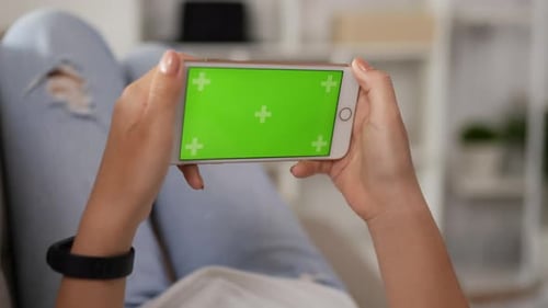 Closeup horizontal of hand woman playing game on smartphone with green screen