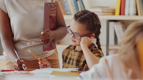 Teacher Helps Student in Classroom at School