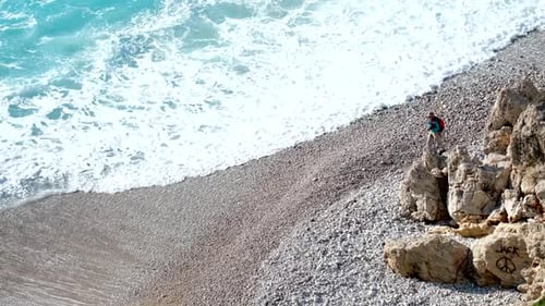 Waves Crashing on Beach With Hiker