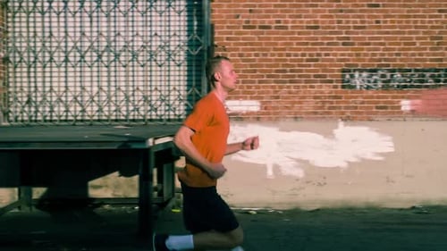 Young Adult Man Running in Urban Alleyway