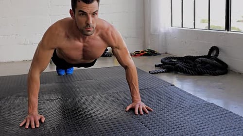 Muscular Man Doing Push-Ups in Gym