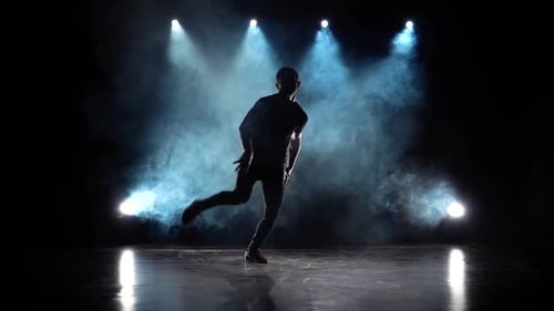 Silhouette of a Talented Young Break Dancer. Hip Hop Street Dance on a Stage in Front of the