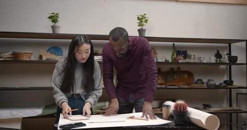 Female Engineer and Black Man Doing Sketch or Plan