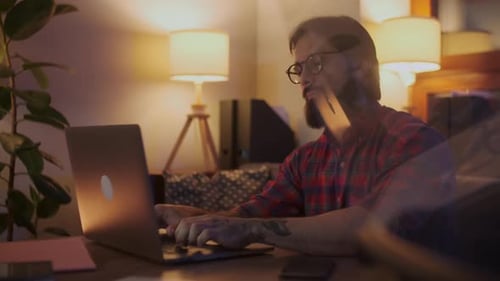 Man Working at Laptop at Home at Night