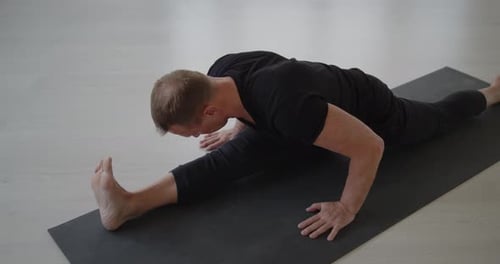 Man Doing Yoga and Stretching on Mat