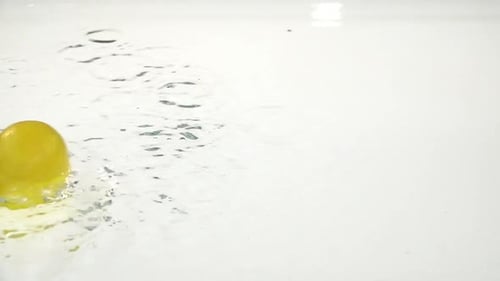 Lemon Splashing into Water on White Background