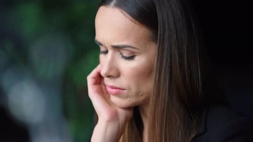 Woman with Long Hair Looks Downward Sadly