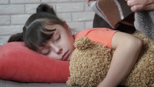 Child Sleeping Peacefully with Teddy Bear at Home