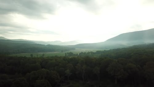 Aerial View of Sunset with Fog Above Forest and Mountains, Morning Foggy Smoke in Magic Rays Light