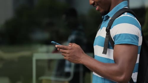 Black Man Typing on Smartphone in the Street