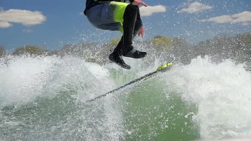 A man wake surfing behind a boat on a lake