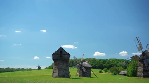 Picturesque Windmills in Rolling Green Field