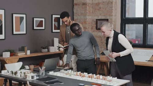 Architects Discussing City Model in Modern Office