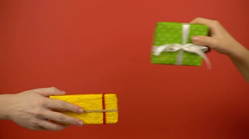 Exchanging Wrapped Gifts on Red Background