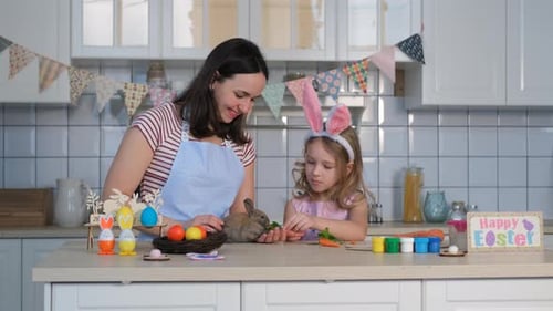 Mother and Child Feed Rabbit in Kitchen