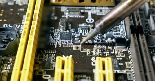 Soldering a Circuit Board with a Soldering Iron. Close-up Shot of Repair at Computers and